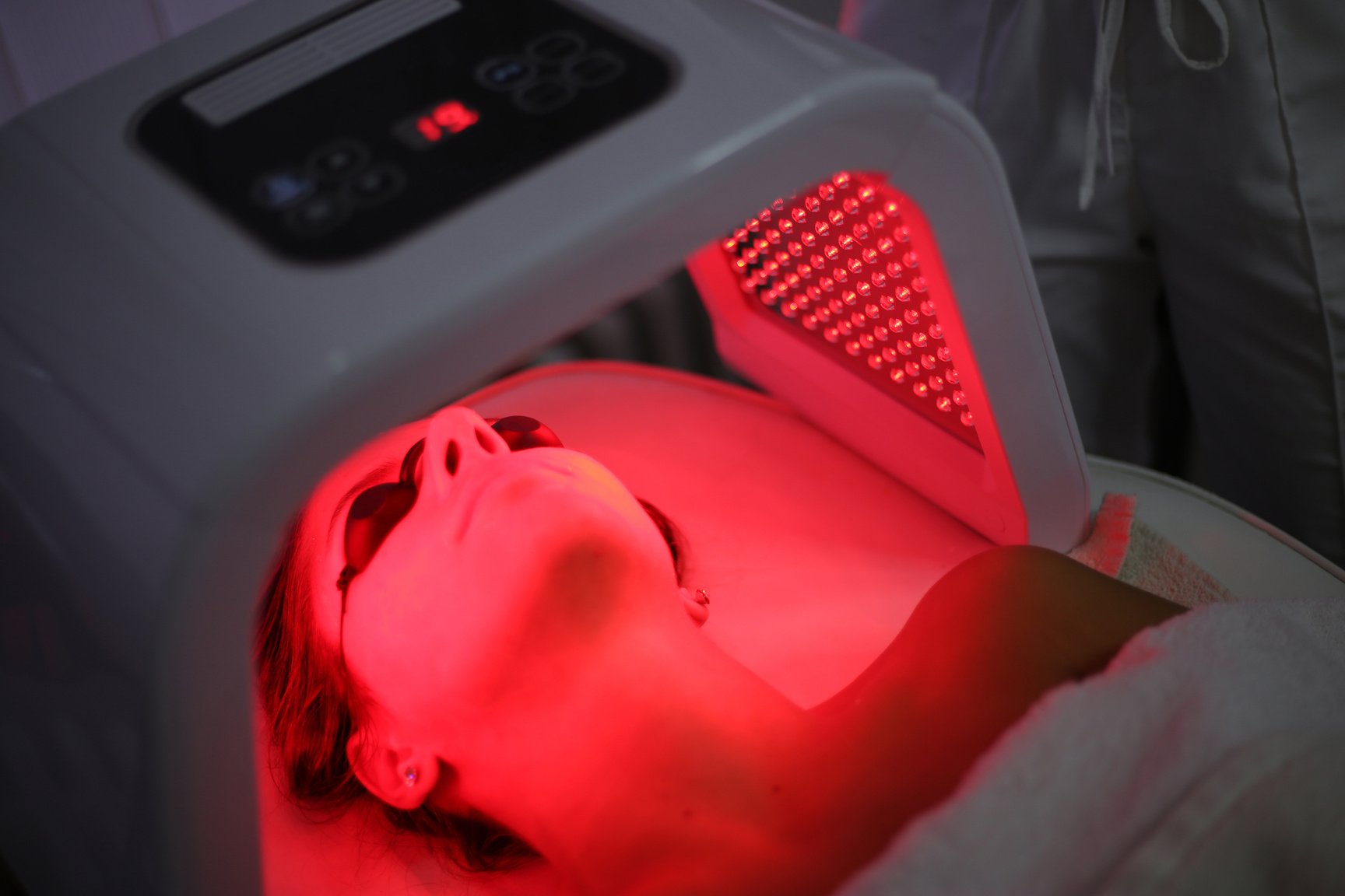 Young woman on light therapy in beauty salon. Omega Light Therapy